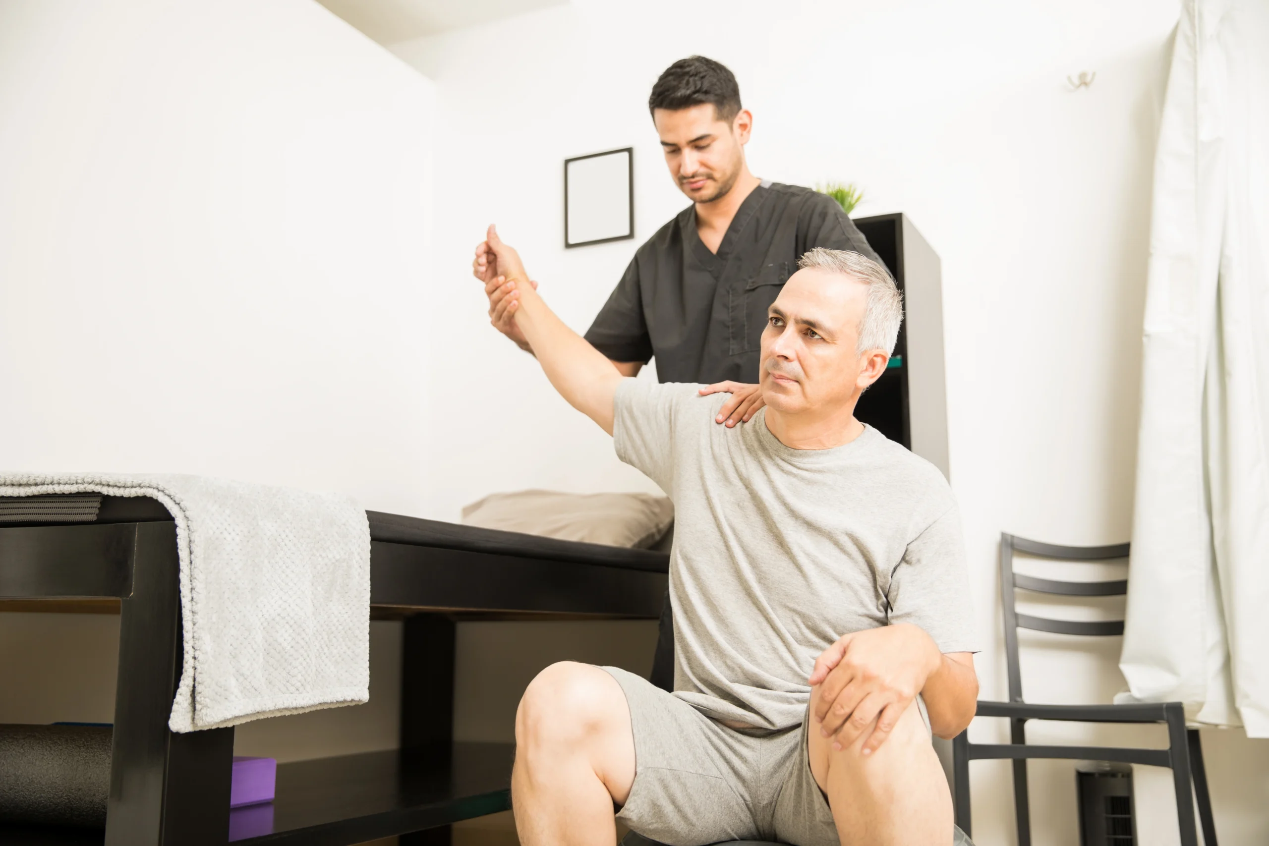 physiotherapist-helping-elderly-patient-with-hand-exercise-physiotherapy-clinic